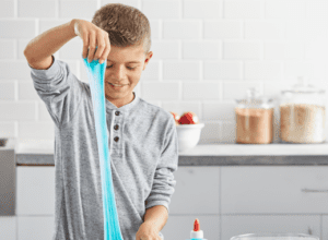 2034490 elmers glow in the dark blue kids playing with slime in the light in use 1